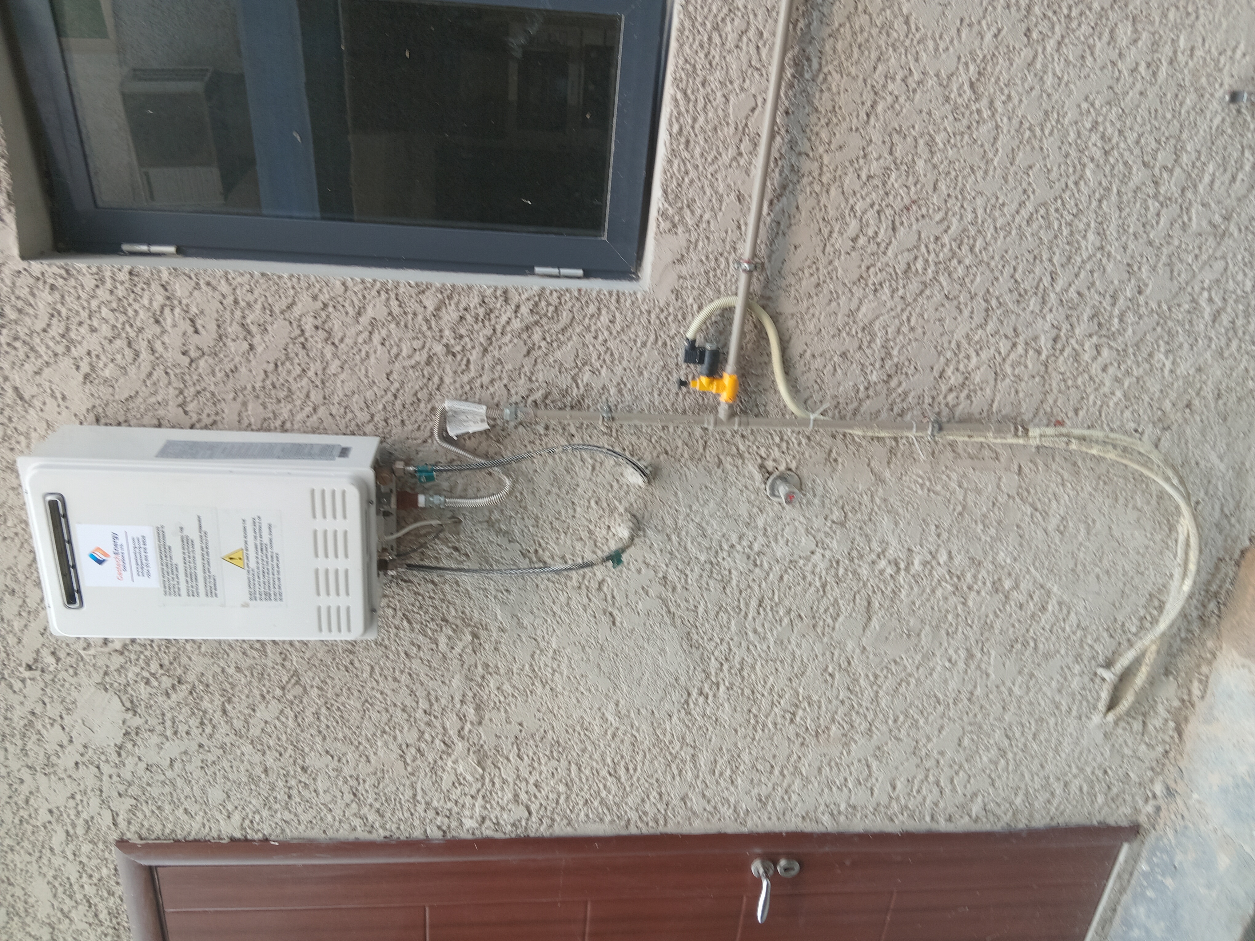 Central gas water heating system with pipes distributing to multiple rooms in Nigerian residential building